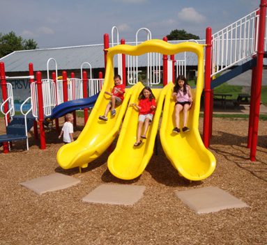 Three children going down slide with Gouglerville foam mats at the bottom