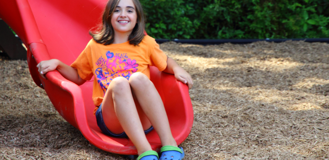 girl at the base of a slide at vangelli park