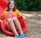 girl at the base of a slide at vangelli park