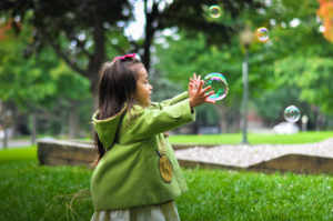 girl playing with bubbles